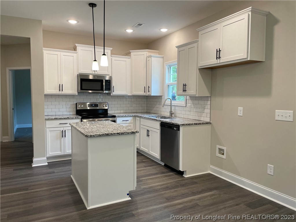 184 Solomon Drive Cameron, NC 28326 - Photo 4 of 13 a kitchen with stainless steel appliances granite countertop a sink a stove a refrigerator and white cabinets