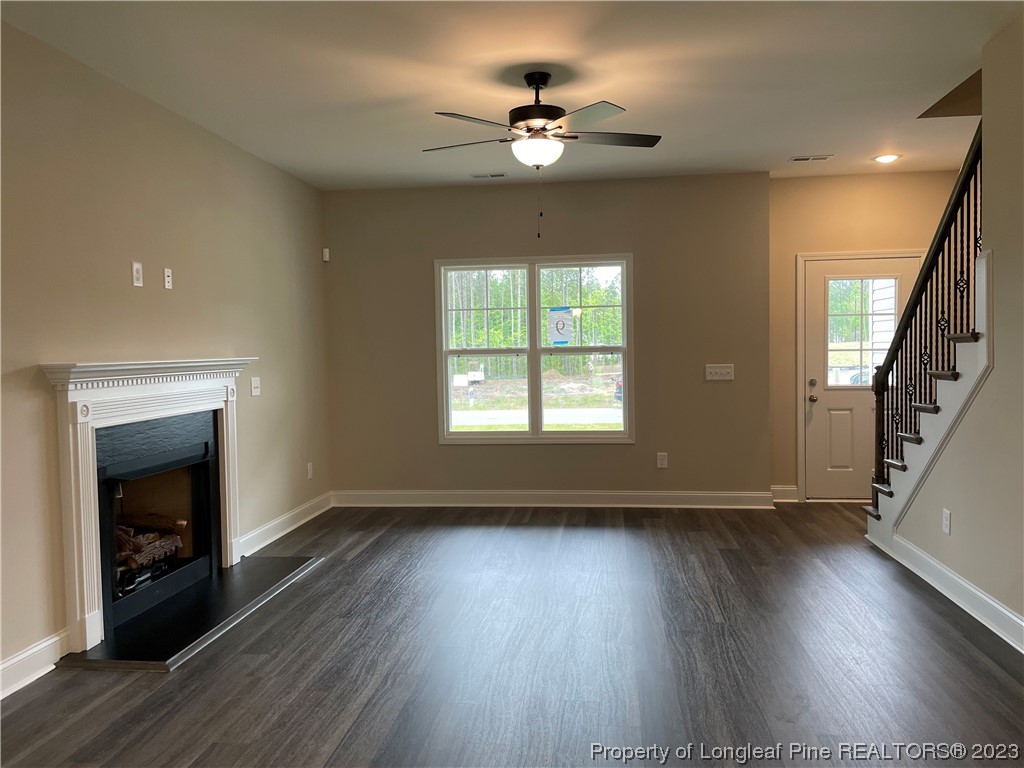 184 Solomon Drive Cameron, NC 28326 - Photo 5 of 13 an empty room with wooden floor fireplace and windows
