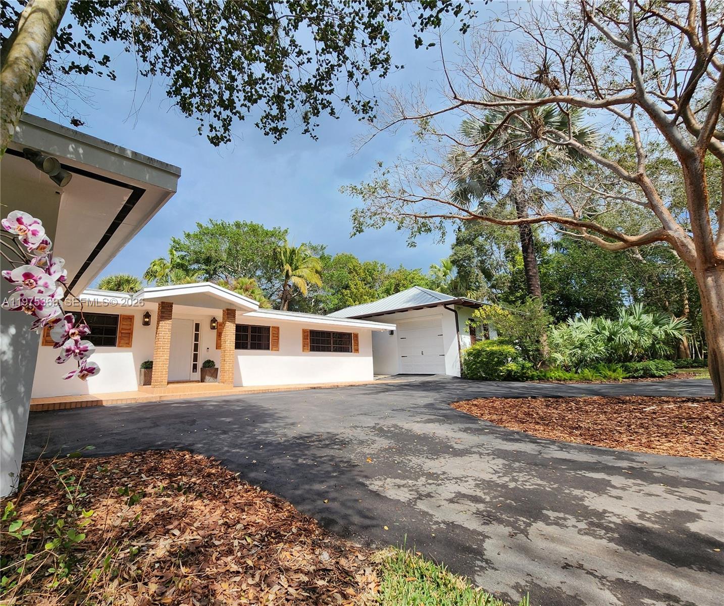 6065 Southwest 133rd Street Pinecrest, FL 33156 - Photo 1 of 41 a front view of a house with a yard