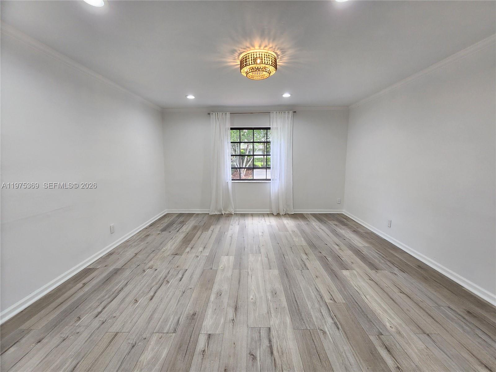 6065 Southwest 133rd Street Pinecrest, FL 33156 - Photo 12 of 41 an empty room with wooden floor and windows