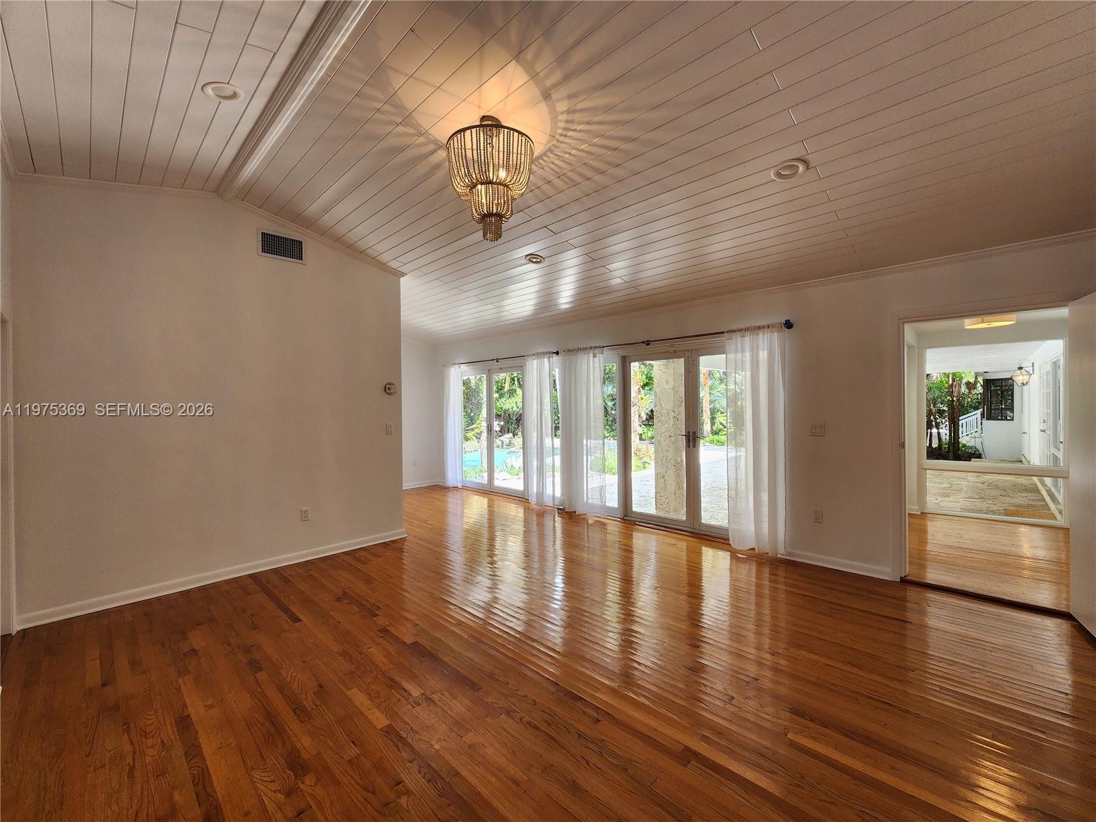 6065 Southwest 133rd Street Pinecrest, FL 33156 - Photo 13 of 41 a view of an empty room with wooden floor and a window