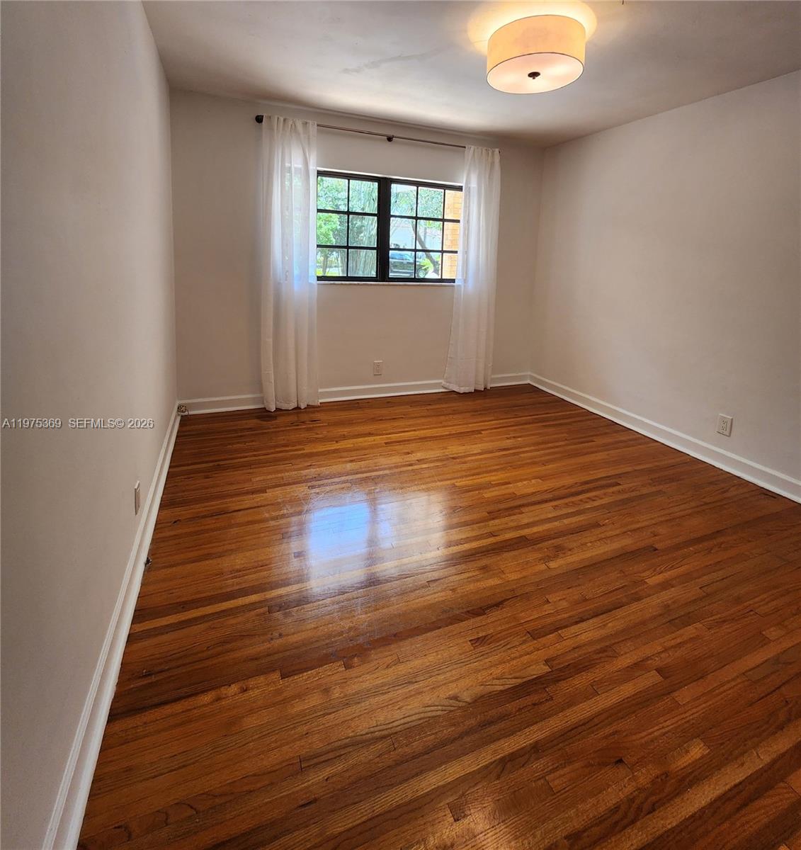 6065 Southwest 133rd Street Pinecrest, FL 33156 - Photo 16 of 41 an empty room with wooden floor and windows