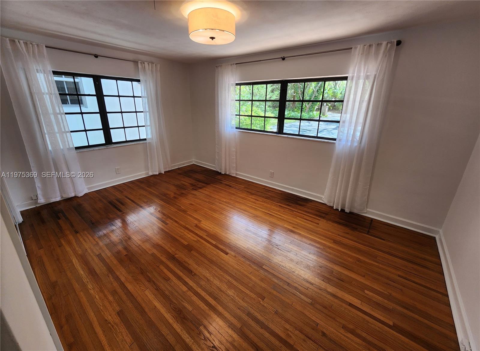 6065 Southwest 133rd Street Pinecrest, FL 33156 - Photo 17 of 41 an empty room with wooden floor and windows