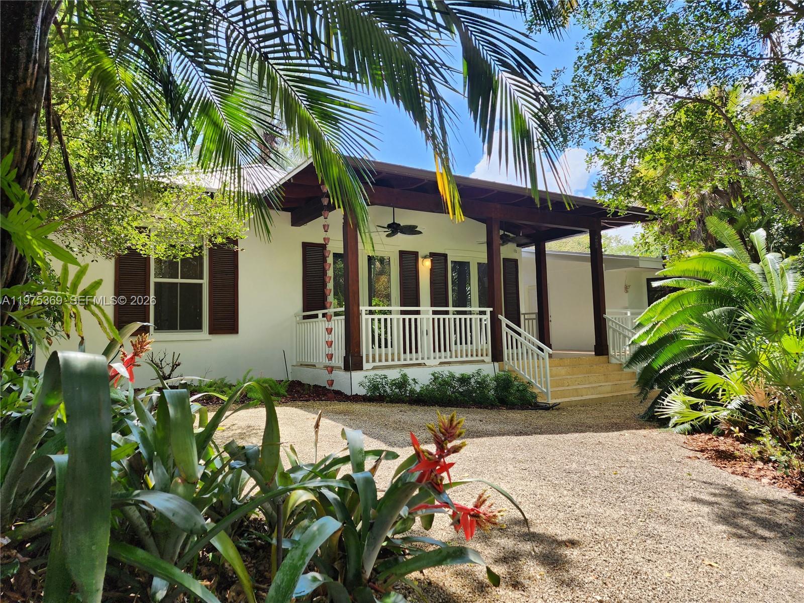 6065 Southwest 133rd Street Pinecrest, FL 33156 - Photo 31 of 41 a front view of a house with a yard