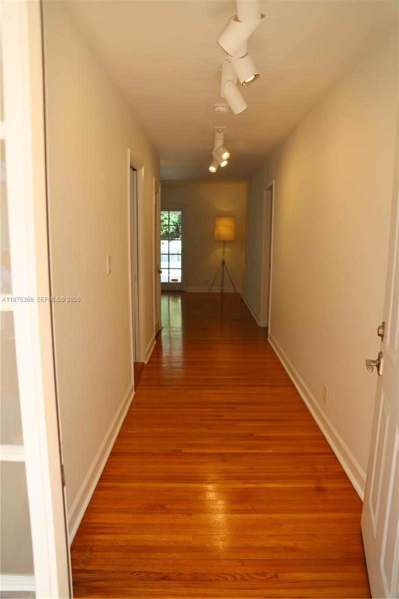 6065 Southwest 133rd Street Pinecrest, FL 33156 - Photo 5 of 41 a view of a hallway with wooden floor
