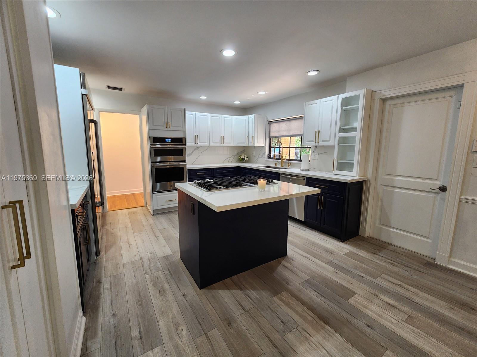 6065 Southwest 133rd Street Pinecrest, FL 33156 - Photo 7 of 41 a kitchen with a refrigerator a sink and cabinets
