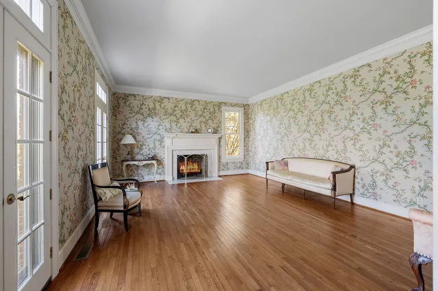 a view of a livingroom with wooden floor staircase and a kitchen