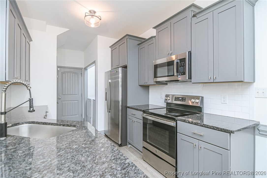 808 Mumford Road Raeford, NC 28376 - Photo 11 of 50 a kitchen with stainless steel appliances granite countertop a sink stove and microwave