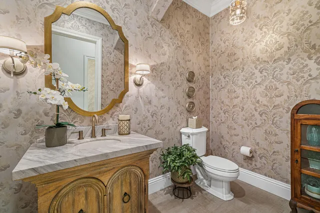 a bathroom with a granite countertop toilet sink and mirror