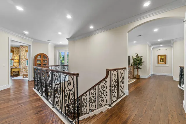 a view of a hallway with wooden floor and windows