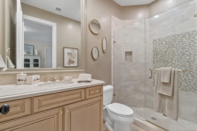 a bathroom with a sink a toilet and shower