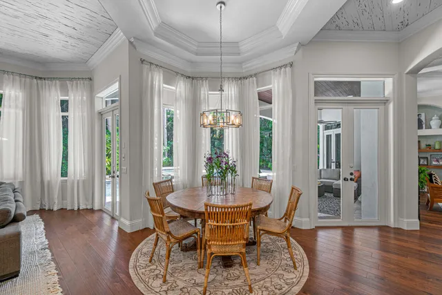 a dining room with furniture a chandelier and wooden floor