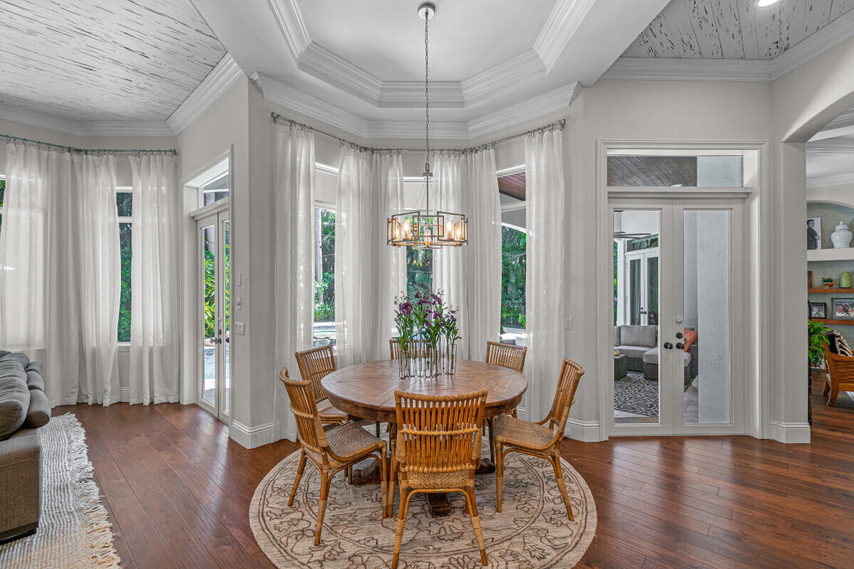 2280 Queen Palm Road Boca Raton, FL 33432 - Photo 9 of 21 a dining room with furniture a chandelier and wooden floor