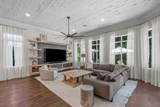 a living room with furniture flat screen tv and a large window