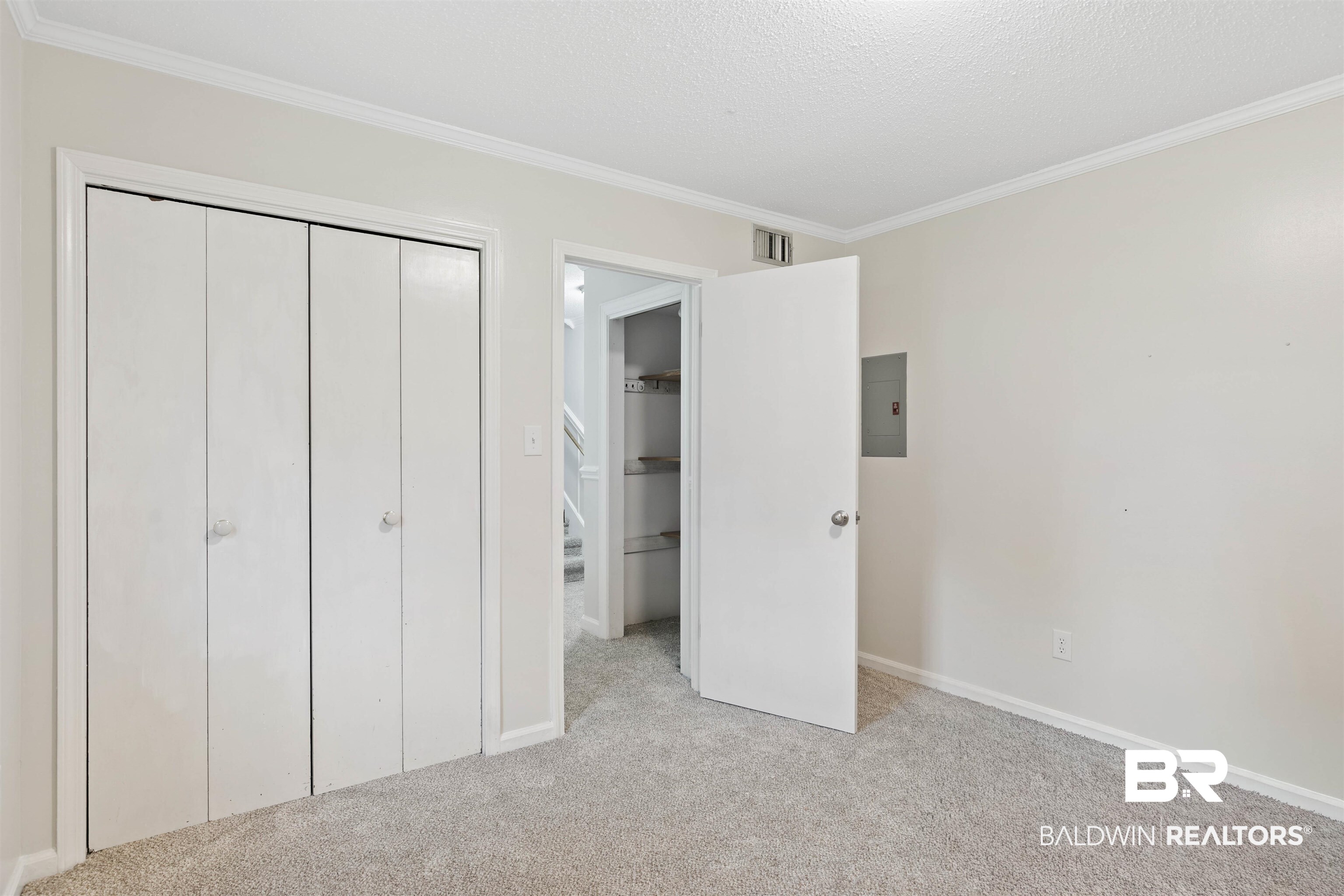 10420 Johnson Road South Mobile, AL 36695 - Photo 35 of 75 Carpeted room featuring bi-fold closet doors, crown molding, and a white interior door