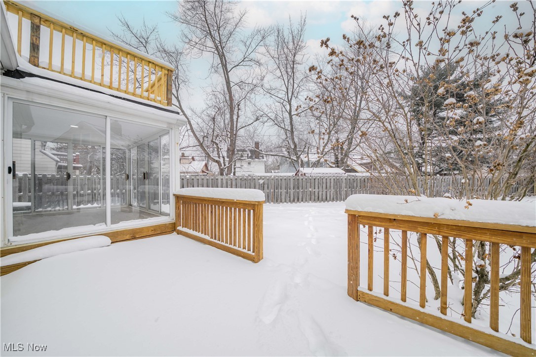 2279 North Taylor Road Cleveland, OH 44112 - Photo 30 of 35 Yard covered in snow with a deck, a sunroom, and a fence
