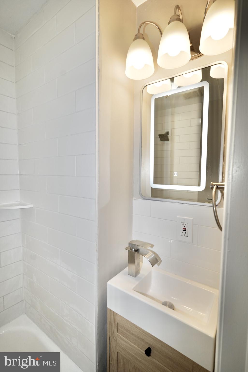2655 Cedar Street Philadelphia, PA 19125 - Photo 9 of 19 a bathroom with a sink a mirror and a vanity