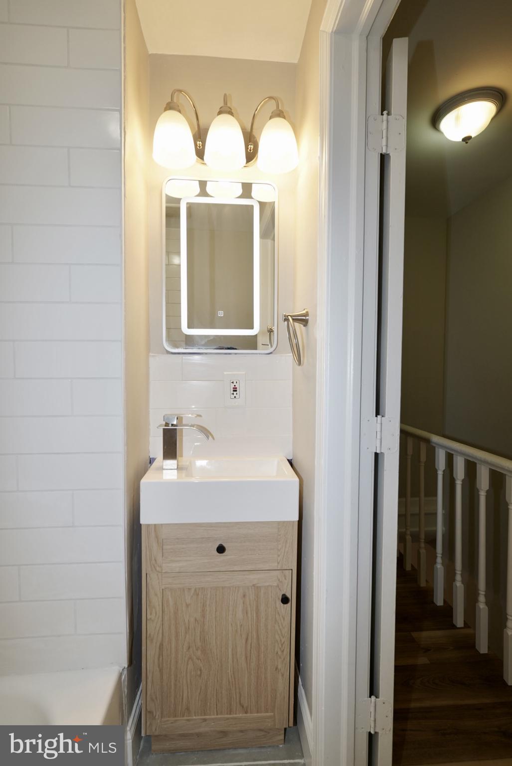 2655 Cedar Street Philadelphia, PA 19125 - Photo 10 of 19 a bathroom with a sink mirror and window