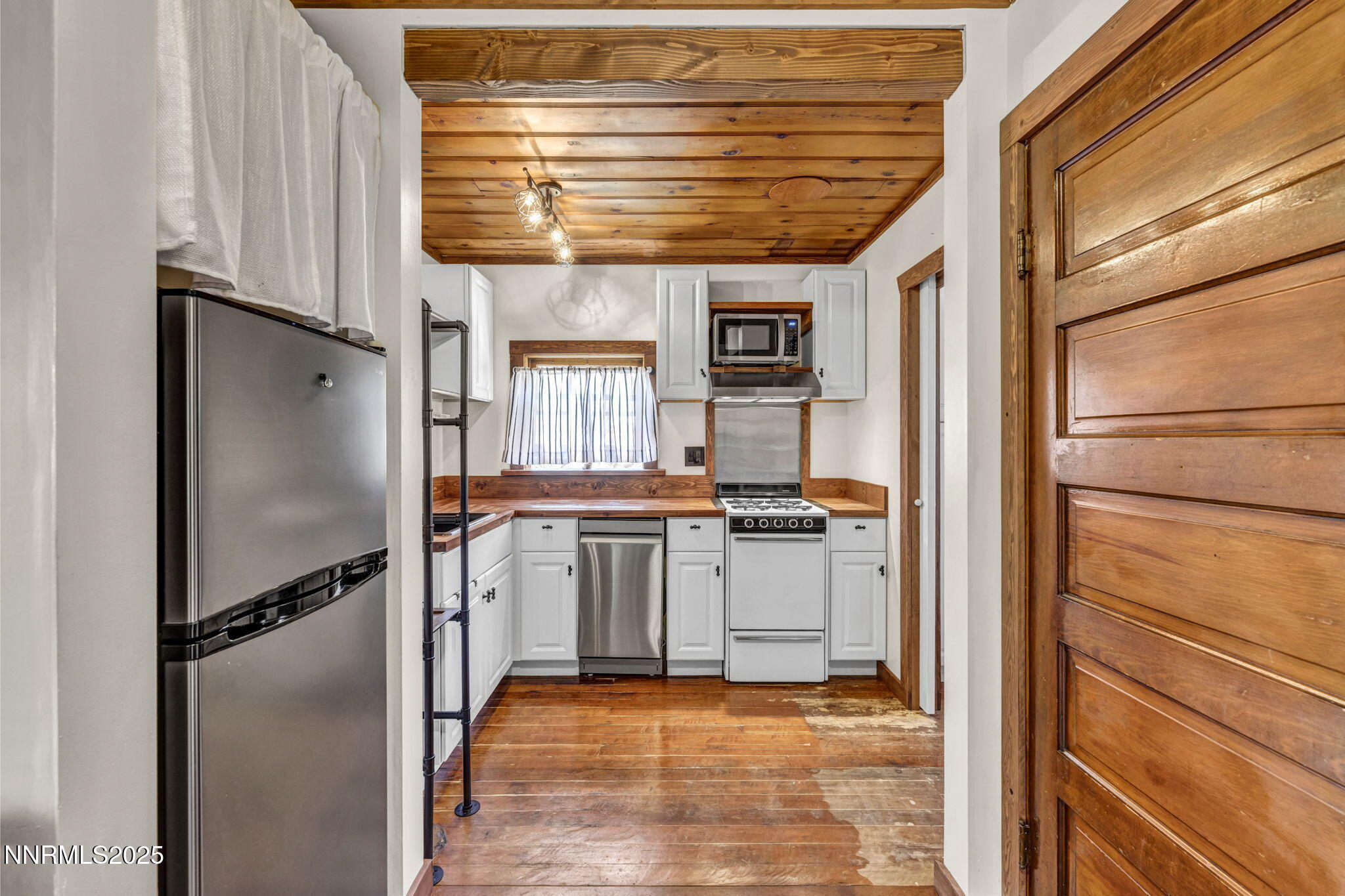 70 4th Street Silver City, NV 89428 - Photo 10 of 29 a kitchen with a refrigerator and white cabinets
