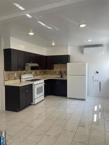 a large kitchen with a large counter top and stainless steel appliances