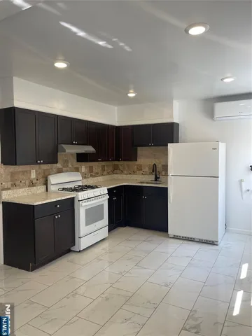 a kitchen with stainless steel appliances granite countertop a refrigerator and a stove top oven