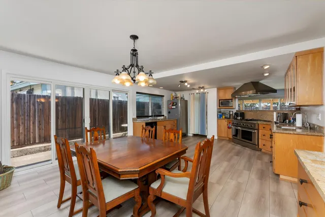a dining room with furniture a chandelier and wooden floor