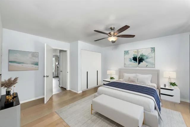 a bedroom with a large bed and a ceiling fan