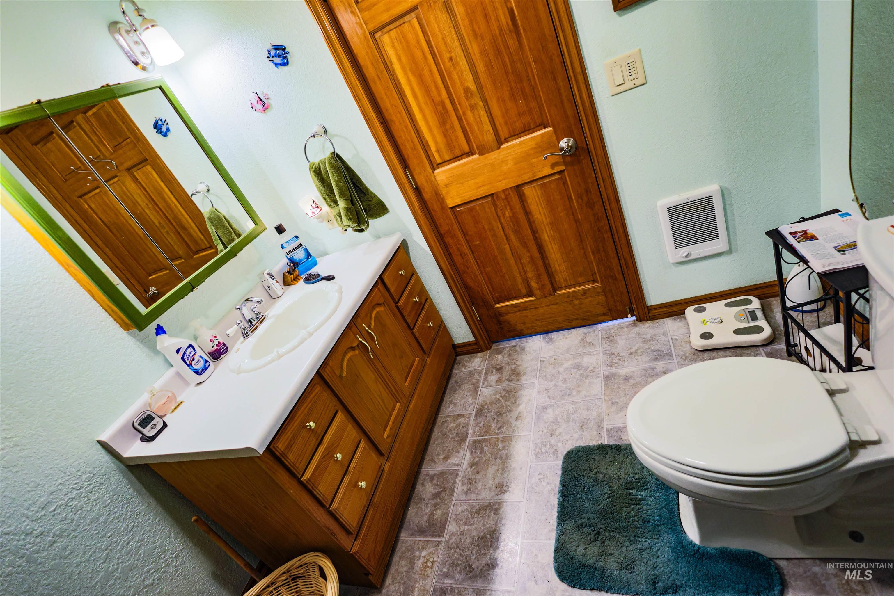 804 Maple Street Kamiah, ID 83536 - Photo 12 of 50 Half bath featuring a textured wall, vanity, and heating unit