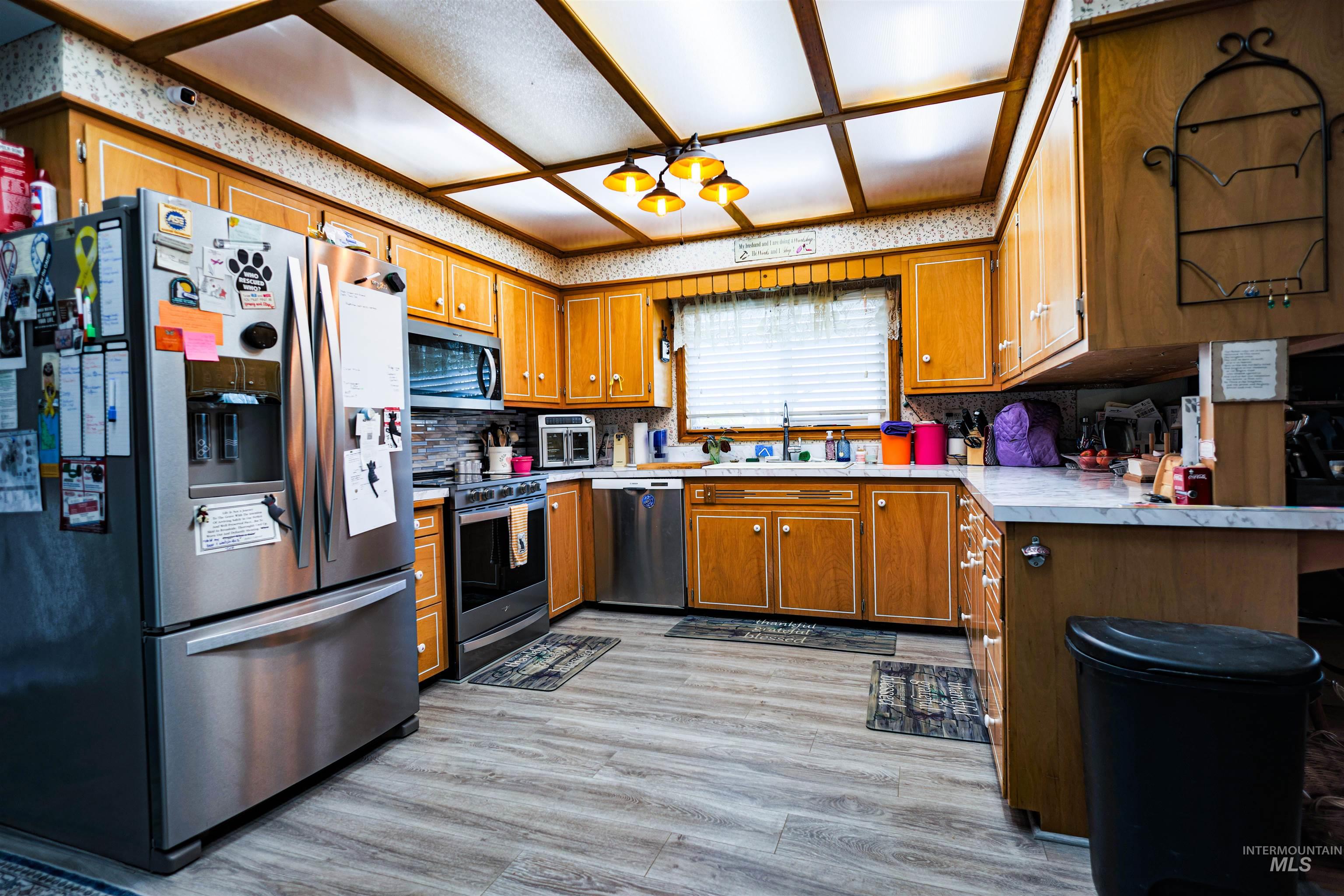 804 Maple Street Kamiah, ID 83536 - Photo 24 of 50 Kitchen with stainless steel appliances, light countertops, wood finish cabinetry, and light wood-style flooring