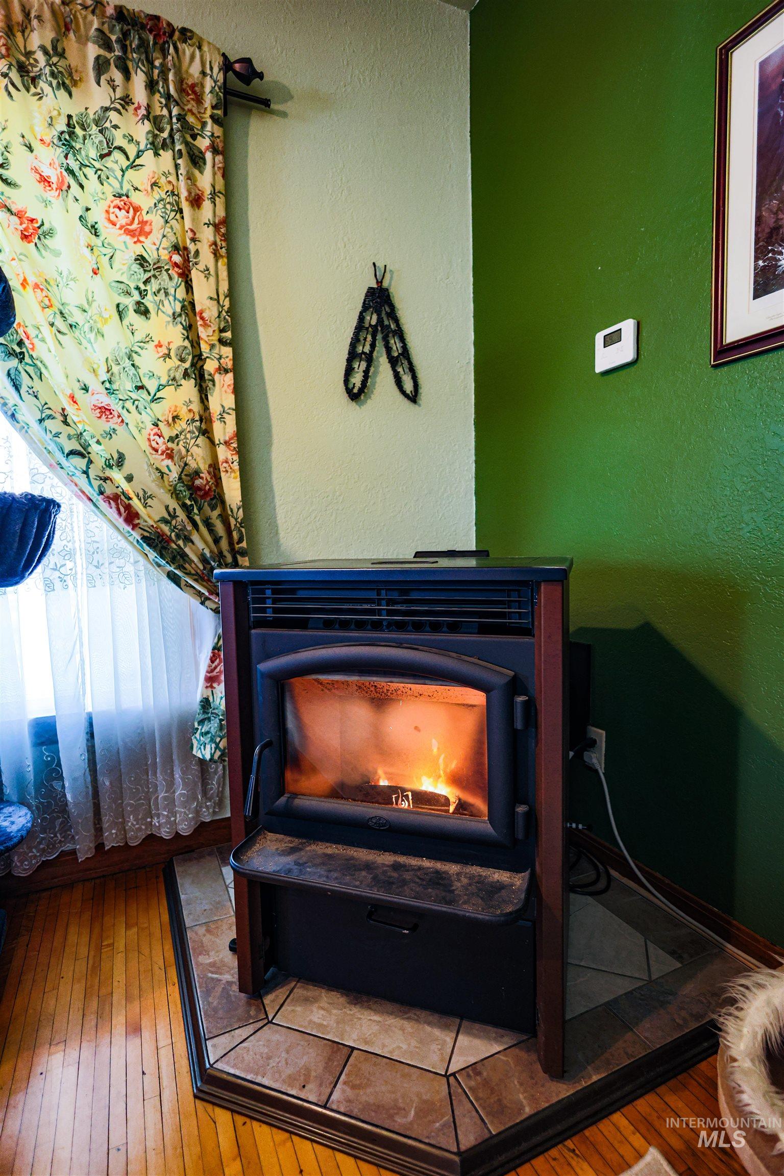 804 Maple Street Kamiah, ID 83536 - Photo 29 of 50 Detailed view of a wood stove, wood finished floors, and a textured wall