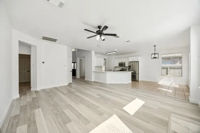 a view of a kitchen with wooden floor and a kitchen space with a sink