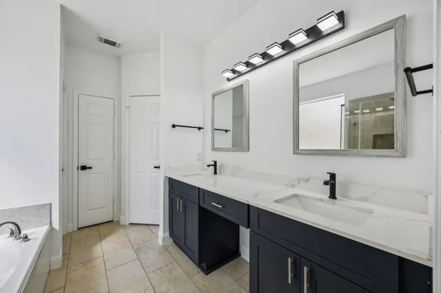 a bathroom with a double vanity sink and mirror