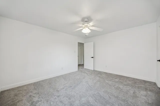 an empty room with a window and a ceiling fan