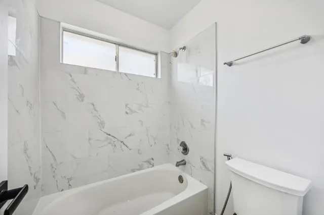 a bathroom with a bathtub a toilet and a shower