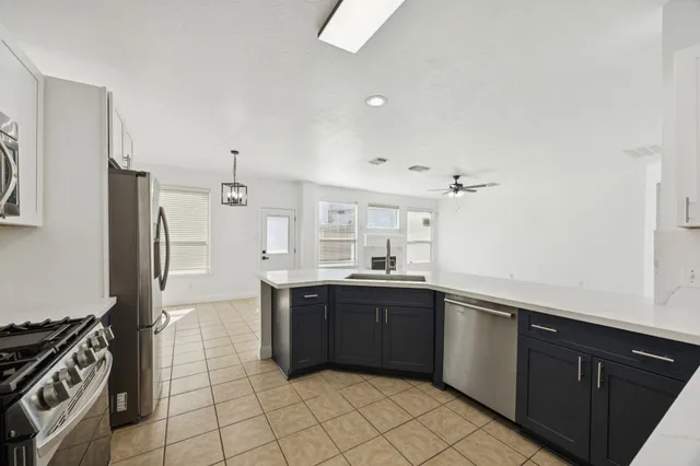 a kitchen with stainless steel appliances granite countertop a sink and a refrigerator