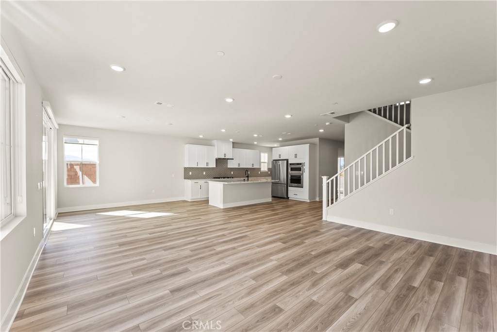 16717 Dara Avenue Chino, CA 91708 - Photo 12 of 41 an empty room with wooden floor and a kitchen