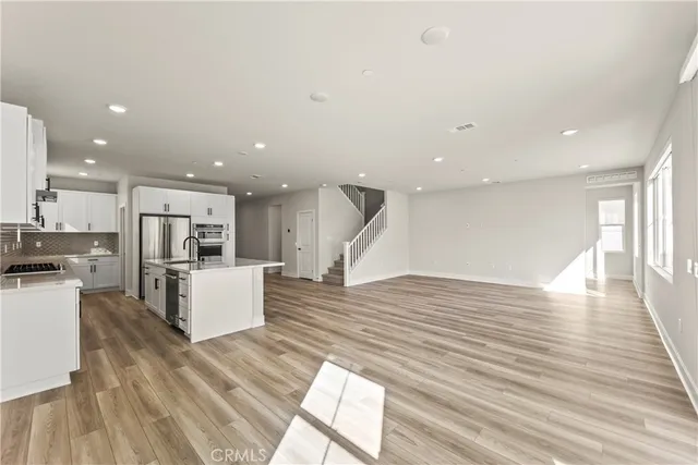 a living room with furniture and kitchen view