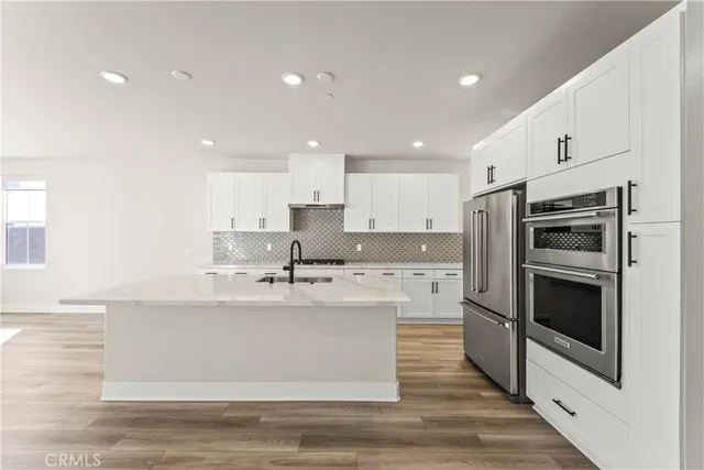 a kitchen with stainless steel appliances kitchen island granite countertop a sink and refrigerator