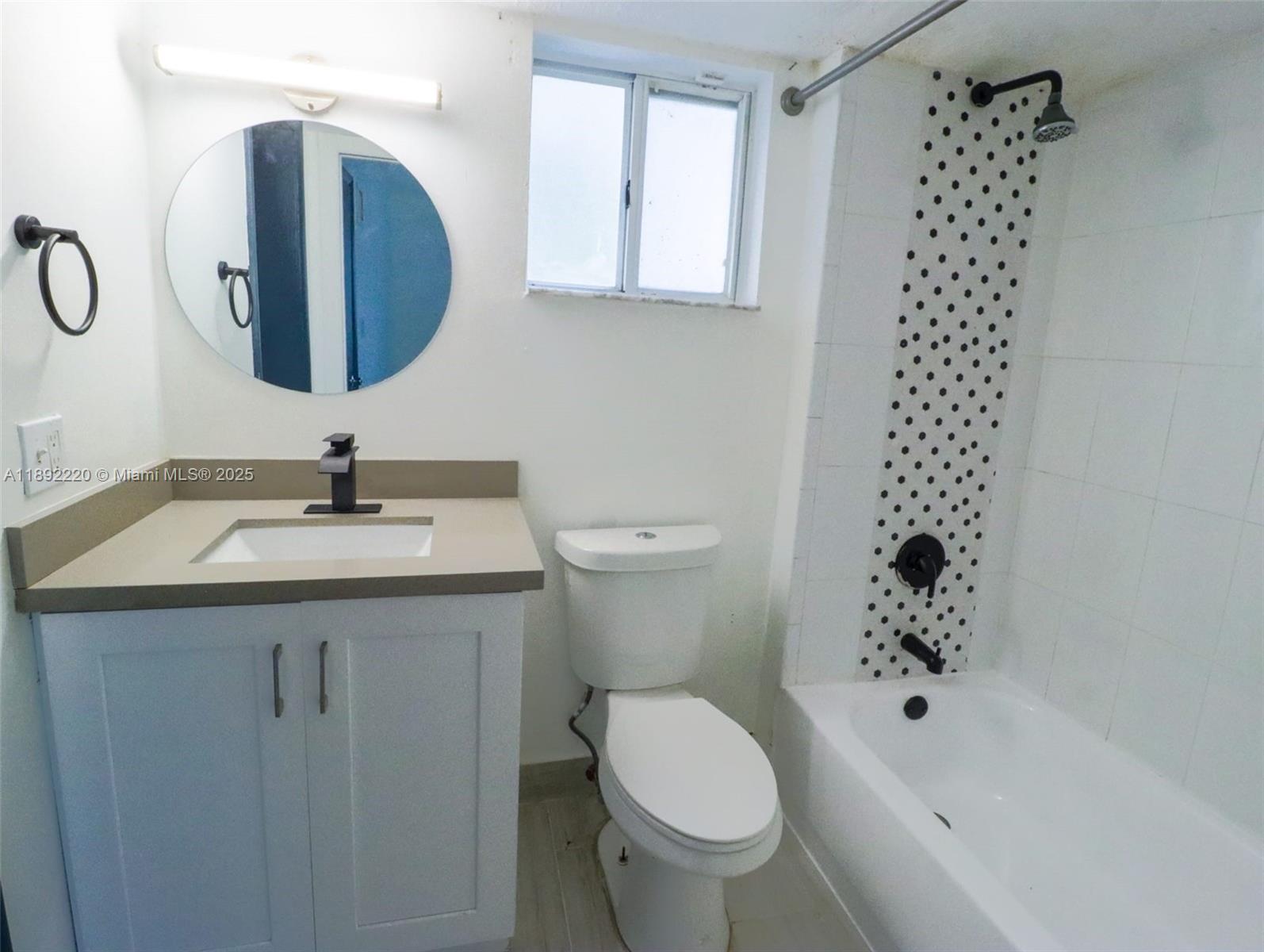 14010 Northeast 3rd Court, Unit 1 Miami, FL 33161 - Photo 11 of 26 a bathroom with a sink a toilet and a mirror