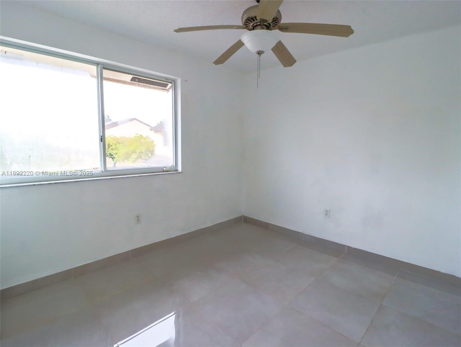 14010 Northeast 3rd Court, Unit 1 Miami, FL 33161 - Photo 22 of 26 an empty room with windows and a ceiling fan