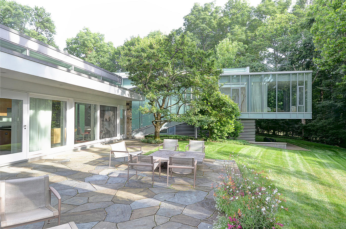 628 West Road New Canaan, CT 06840 - Photo 27 of 28 a view of a chair and tables in the backyard of the house
