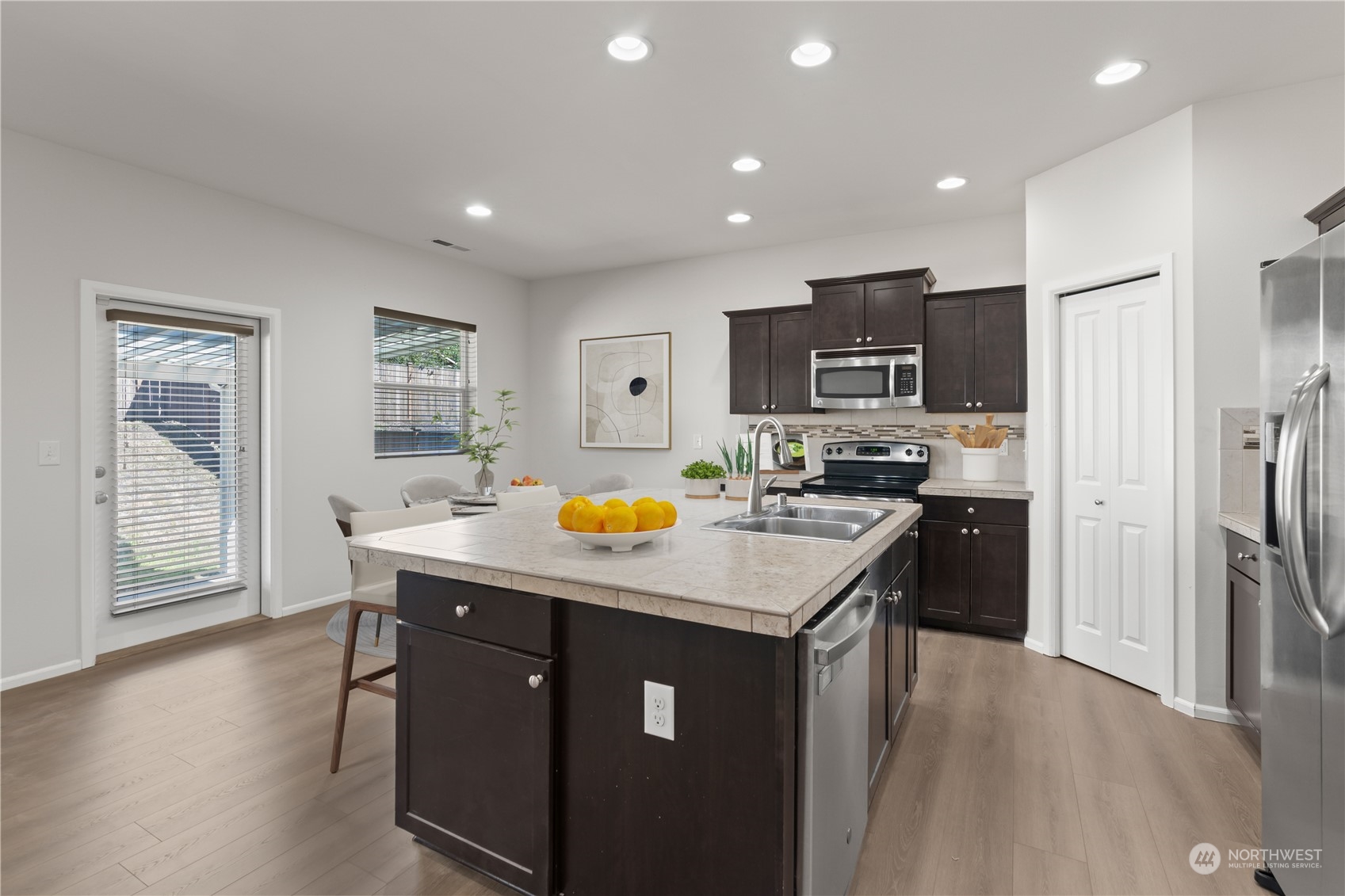 7004 Raptor Avenue Northeast Olympia, WA 98516 - Photo 8 of 28 a kitchen with stainless steel appliances granite countertop a refrigerator a stove top oven a sink dishwasher and wooden cabinets with wooden floor