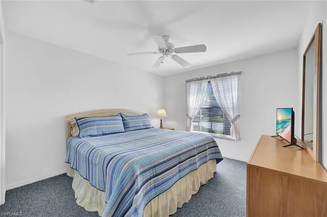 a bedroom with a bed desk and a window