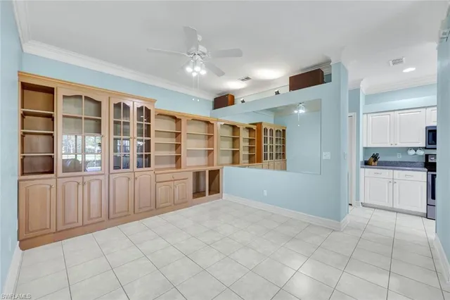a large white kitchen with granite countertop a large counter top space appliances and cabinets