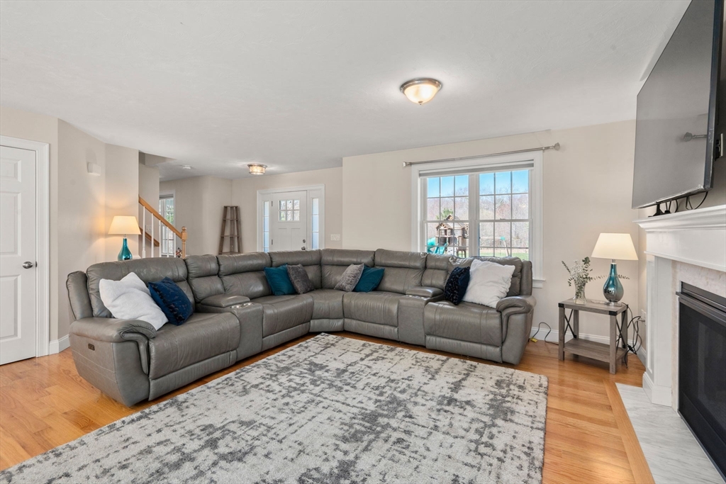 5 Glebe Street Rehoboth, MA 02769 - Photo 11 of 42 a living room with furniture a fireplace and a flat screen tv