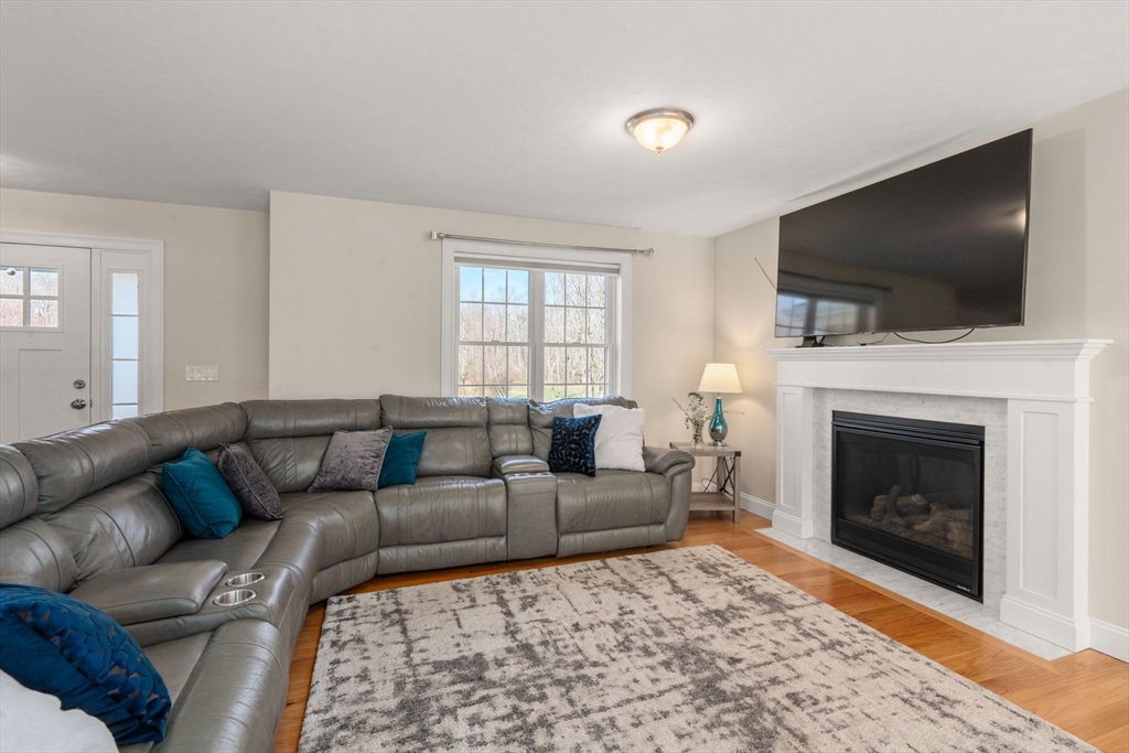 5 Glebe Street Rehoboth, MA 02769 - Photo 12 of 42 a living room with furniture a flat screen tv and a fireplace
