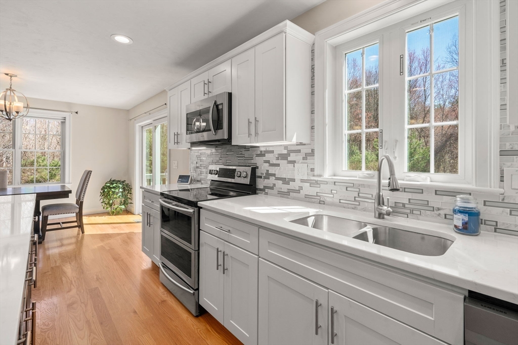 5 Glebe Street Rehoboth, MA 02769 - Photo 7 of 42 a kitchen with stainless steel appliances granite countertop a sink a stove and a wooden cabinets