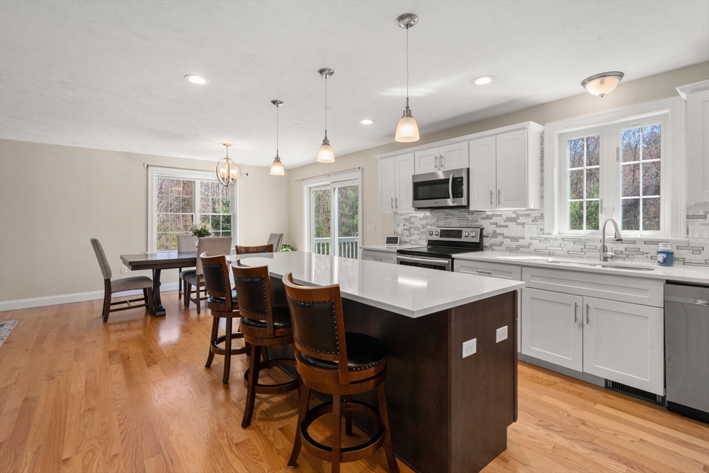5 Glebe Street Rehoboth, MA 02769 - Photo 8 of 42 a kitchen with stainless steel appliances kitchen island granite countertop a stove a sink a dining table and chairs