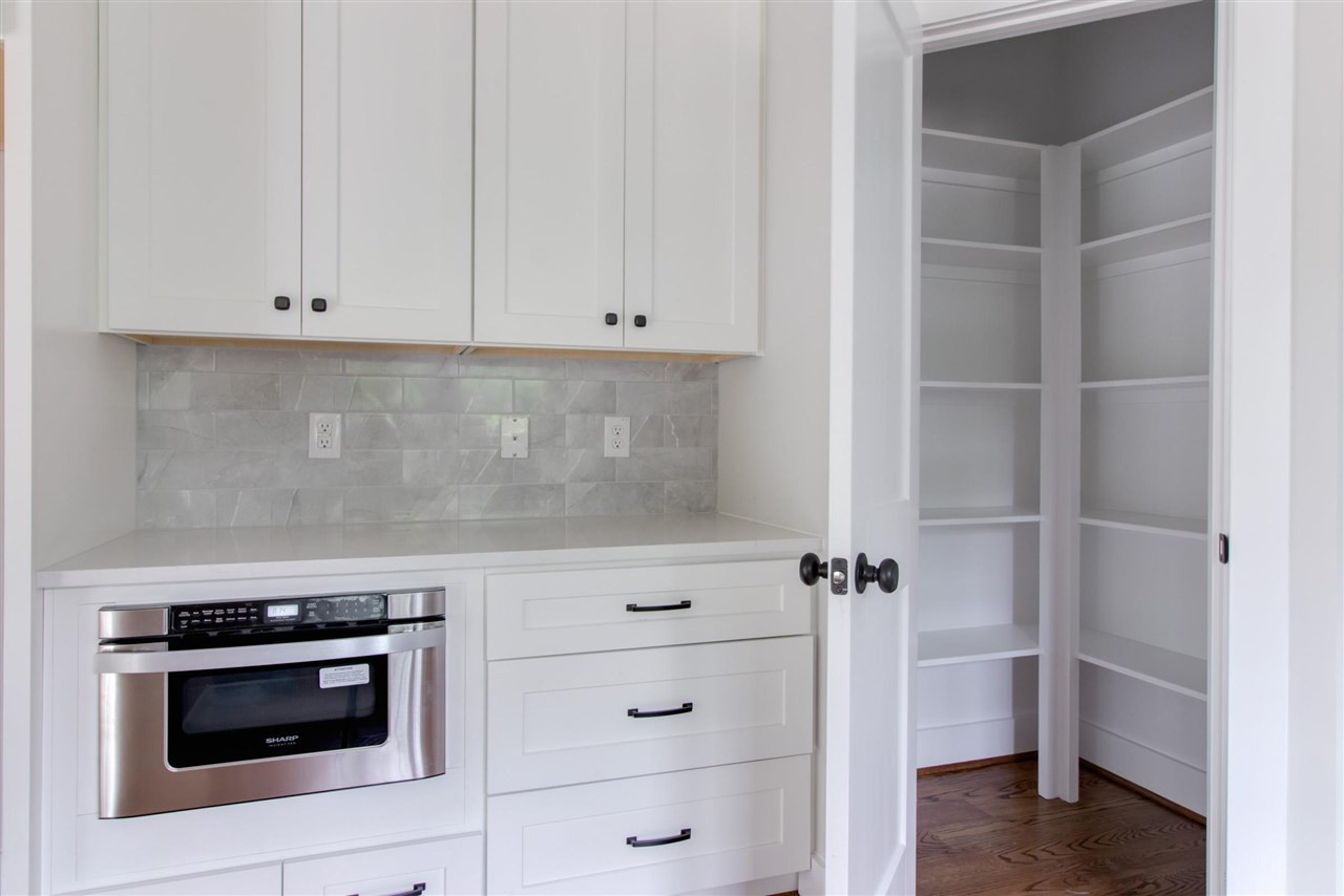 2929 Chapel Hill Road Durham, NC 27707 - Photo 11 of 25 a kitchen with white cabinets and white appliances