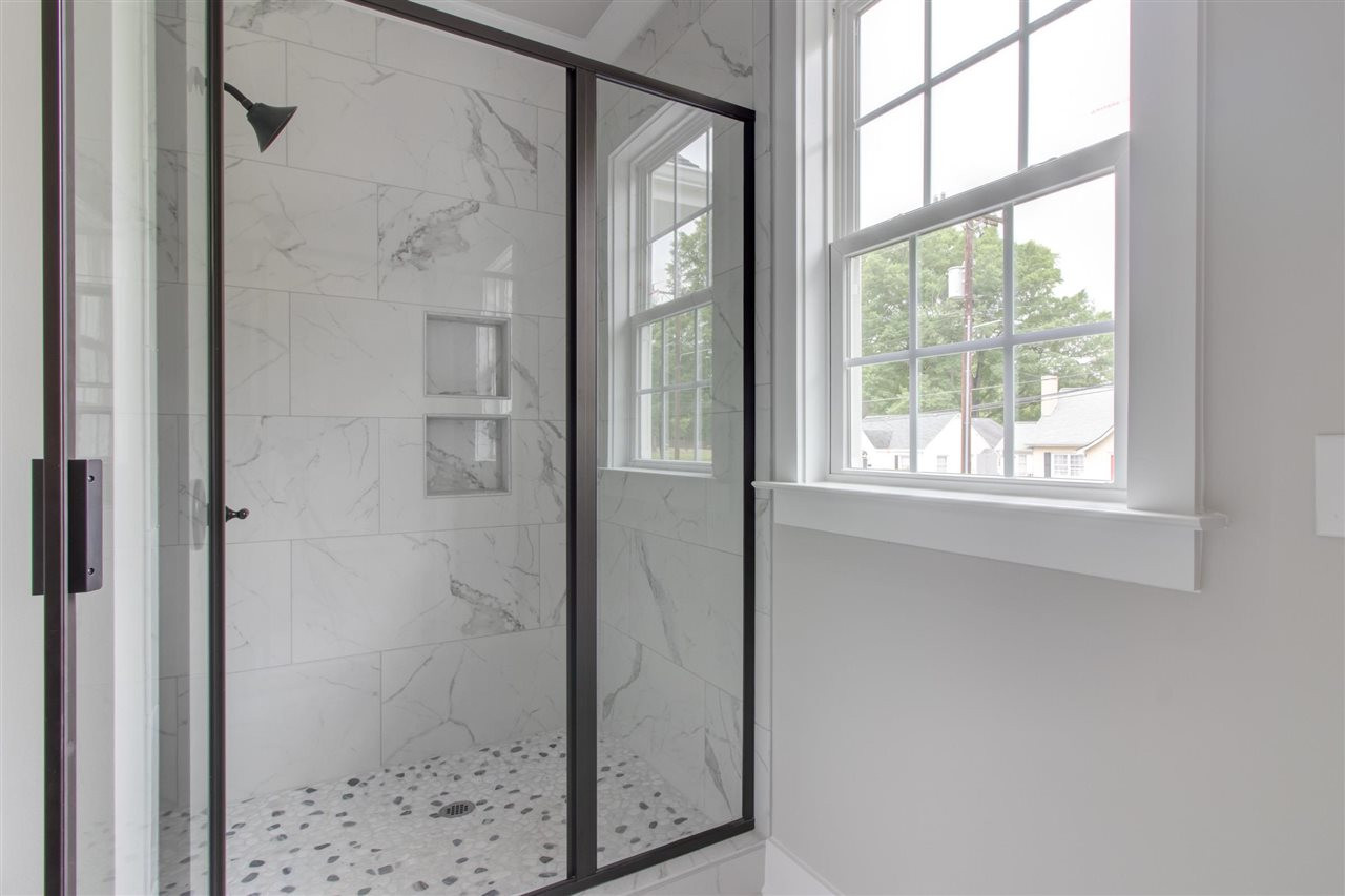 2929 Chapel Hill Road Durham, NC 27707 - Photo 19 of 25 a bathroom with a glass shower door and a window
